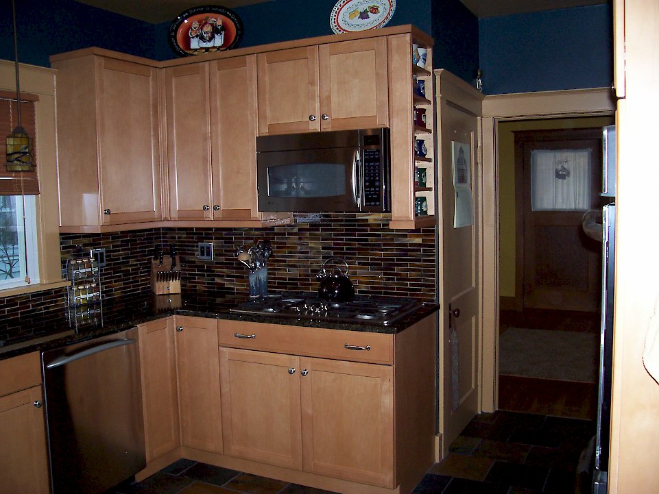 A stainless hood microwave and gas cooktop.